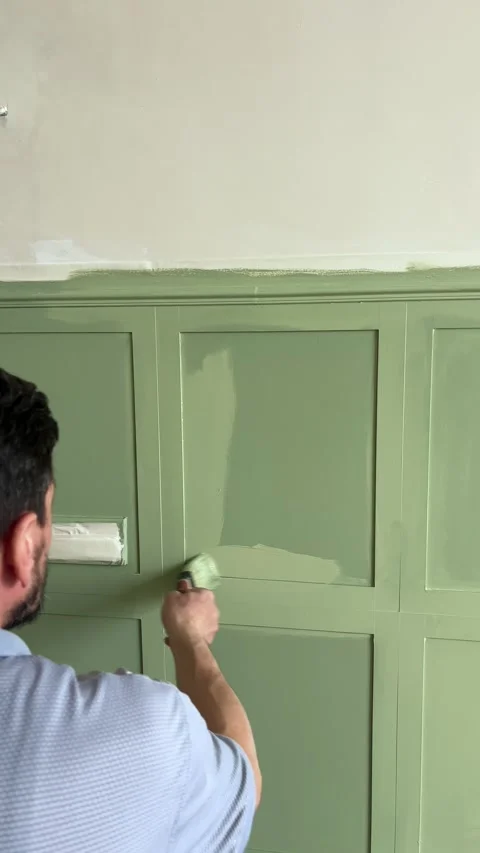 Painting wall-mounted MDF panels with interior green paint in the bedroom Stock Footage 346689636