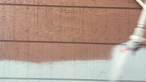 Painting wall white using airless gun sprayer, house facade renovation Stock Footage 146510963