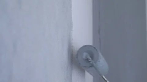 Painting white wall in gray using paint roller, closeup side view. Stock Footage 123572317