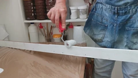 Painting white on wood using a sponge roller. Close up. Time lapse. Stock Footage 148347308