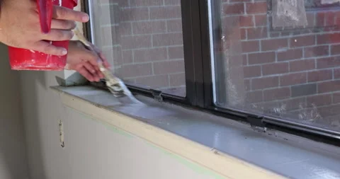 Painting window frame during home renovation near brick wall Stock Footage 339013712
