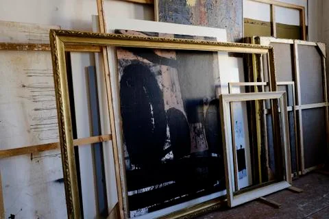 Paintings and frames leaning on wall Stock Photos