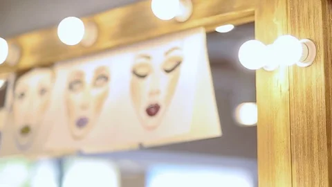 Paintings of a make up appied on faces hanging on the mirror Video stock 76080933