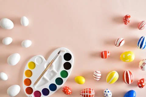 Paints and Easter colored eggs on a beige background. Copy space. Flat lay, t Foto stock