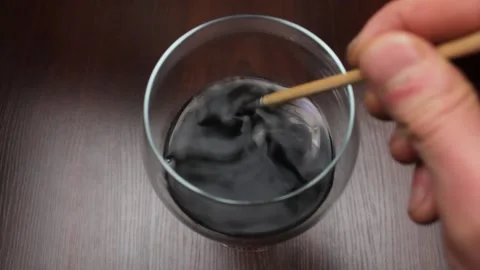Paints in a glass of water. Brush with black paint in water. Stock Footage 184471653