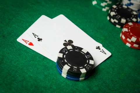 A pair of aces on the table with a pile of poker chips Stock Photos