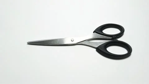 A pair of black handled scissors on a white background. Stock Photos