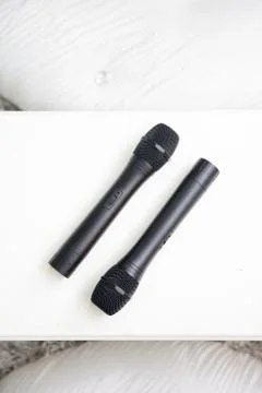 A pair of black microphone on a white table Stock Photos