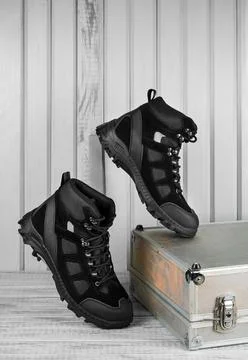 Pair black textile work boots for safe winter with steel toe,wooden background Foto stock