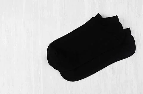 Pair blank black small, low socks flat lay on white wood board, side view - m Stock Photos