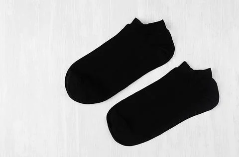 Pair blank black small, low socks flat lay on white wood board, side view - m Stock Photos