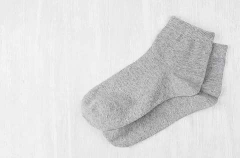 Pair blank grey medium socks flat lay on white wood board, side view - mock u Stock Photos