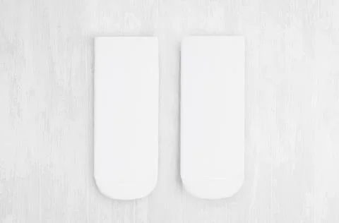 Pair blank white medium socks flat lay on white wood board, front view - mock Stock Photos