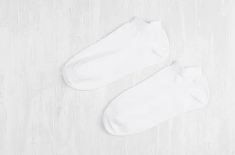 Pair blank white small, low socks flat lay on white wood board, side view - m Stock Photos