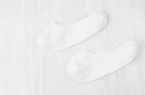 Pair blank white small, low socks flat lay on white wood board, side view - m Stock Photos