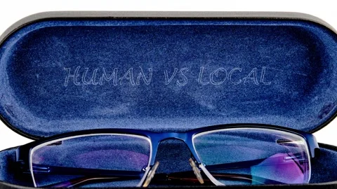 A pair of blue framed eyeglasses lies open in a blue velvet case with Human vs Stock Footage 333645643