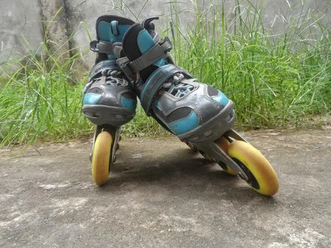 A pair of blue inline skates is placed in an upright position. Stock Photos