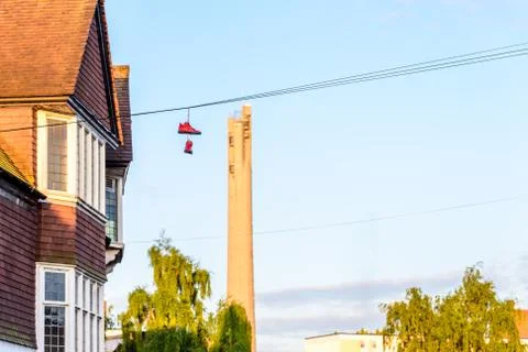 Pair of boots hanging on power lines in English Town Stock-Fotos