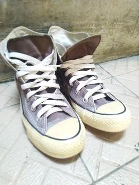 A pair of brown canvas high-top sneakers are displayed with white laces on a  Stock Photos
