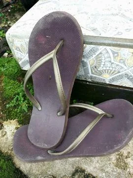 A pair of brown flip-flops is in front of the terrace Foto stock