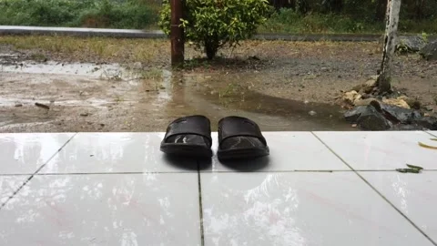 A pair of brown rubber sandals on a raindrop background Stock Footage 205379338