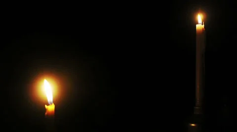 A pair of candles glows steadily in the dark. Stock Footage 32187249