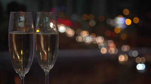 Pair of champaign glasses against a night city lights on background. Stock Footage 60057526