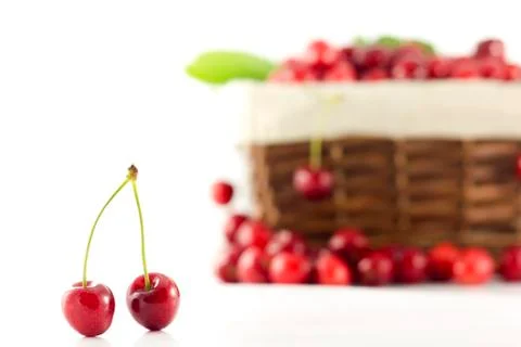 A pair of cherries with a basket in the background Stock Photos
