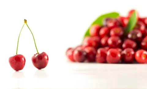 A pair of cherries with group of cherries in the background Stock Photos