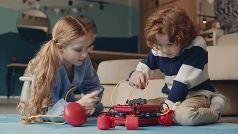 Pair of Children Lying on Floor and Constructing Robot Video stock 153466201