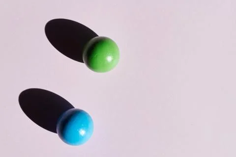 A pair of colored balls on a light background with hard shadows. abstract bac 库存照片
