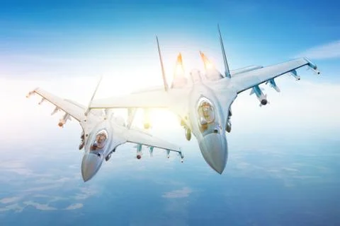 Pair of combat fighters, in conjunction flying in the sky over the territory. Fotos Stock