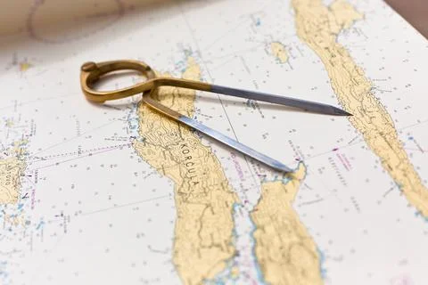 Pair of compasses for navigation on a sea map with low depth of field Stock Photos