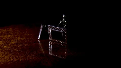 A pair of cufflinks ligthing on a dark background Stock Footage 102327208