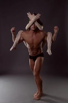 A pair of dancers in an elegant acrobatic pose against a dark background. Foto stock
