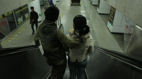 Pair down the escalator in a Chinese subway Stock Footage 46434436
