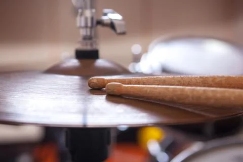 Pair of drumsticks lying on cymbal. Stock Photos