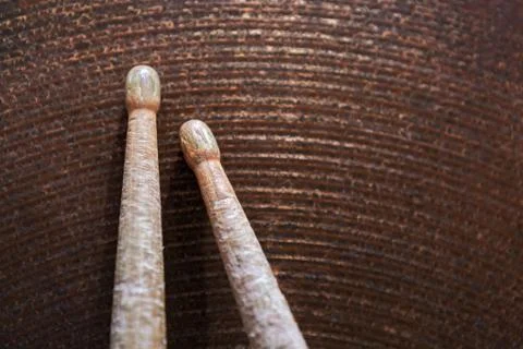 Pair of drumsticks lying on cymbal. Stock Photos