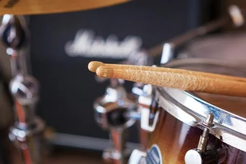 Pair of drumsticks lying on tom-tom drum. Stock Photos