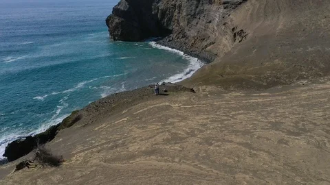 Pair on the edge of cliff and stunning seascape. Aerial of Capelinhos volcano Stock Footage 117305358