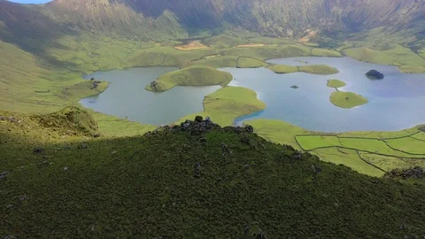 Pair on the edge of huge caldera. Sunlit lake and meadow on the top of extinct Stock Footage 119891995