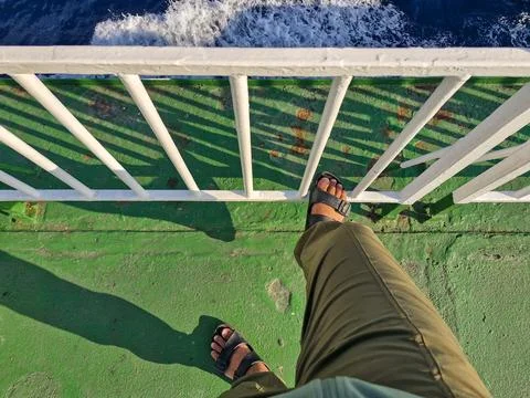 A pair of feet on the deck of a ferry Stock Photos