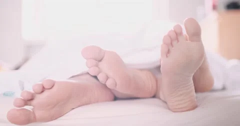 Pair of feet playing footsie at home in ... | Stock Video | Pond5