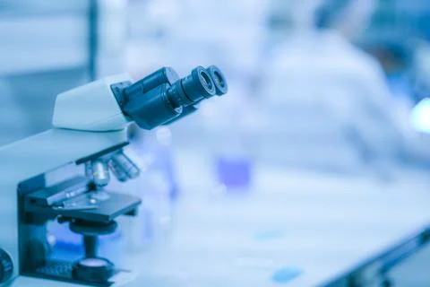 A pair of female lab technicians in white lab coats, hairnets and clear saf.. Stock Photos