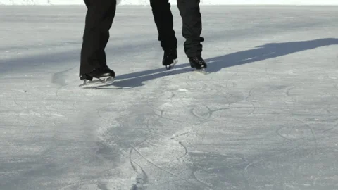 A pair of figure skaters in black skates learn a waltz on ice outdoors Stock Footage 232991403
