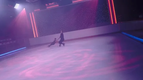 Pair of figure skaters rotating on ice rink,woman goes into death spiral,hovers Stock-Footage 178753980