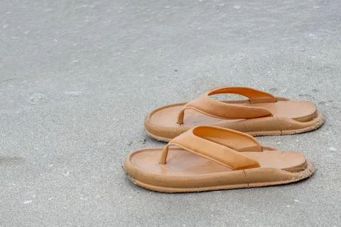 A pair of flip-flops on the beach sand Stock Photos