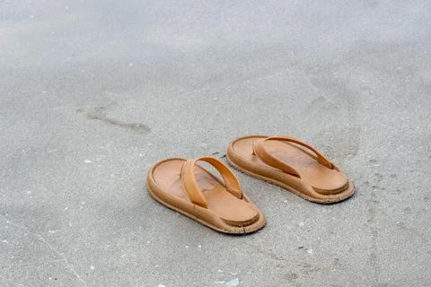 A pair of flip-flops on the beach sand Stock Photos