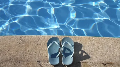 Pair of flip flops by the poolside Stock Footage 102386398