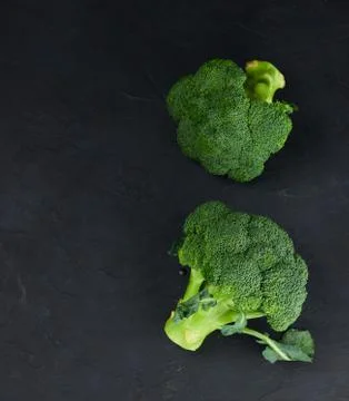 A pair of fresh, raw, broccoli on a black background. the view from the top.  Stock Photos